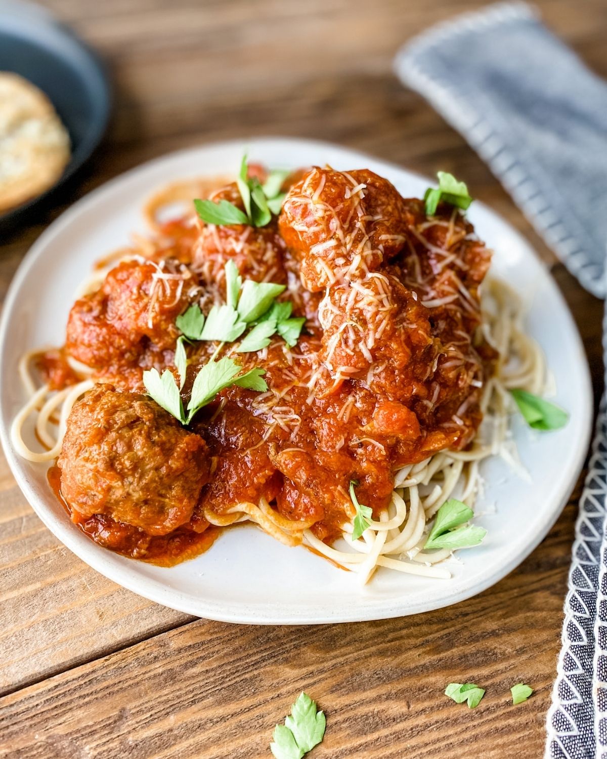 gluten-free meatballs on a plate with sauce and parsley.
