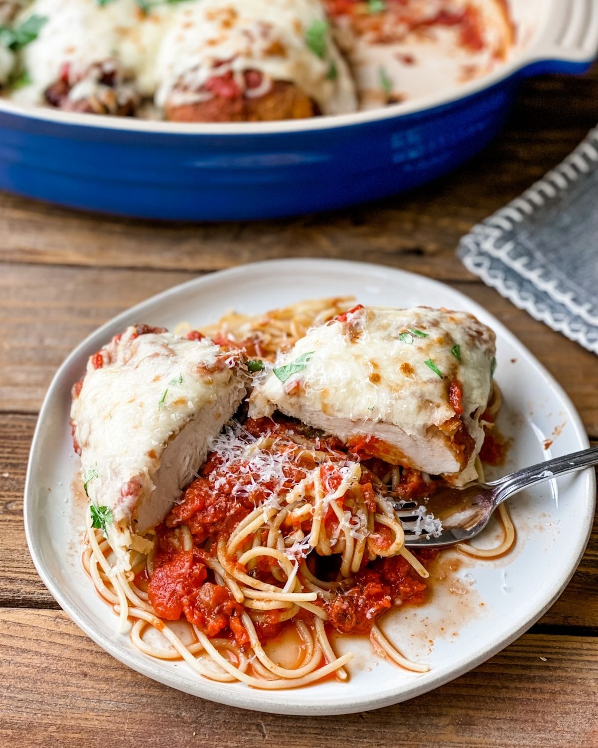 gluten-free chicken parm on a plate with pasta and sauce.