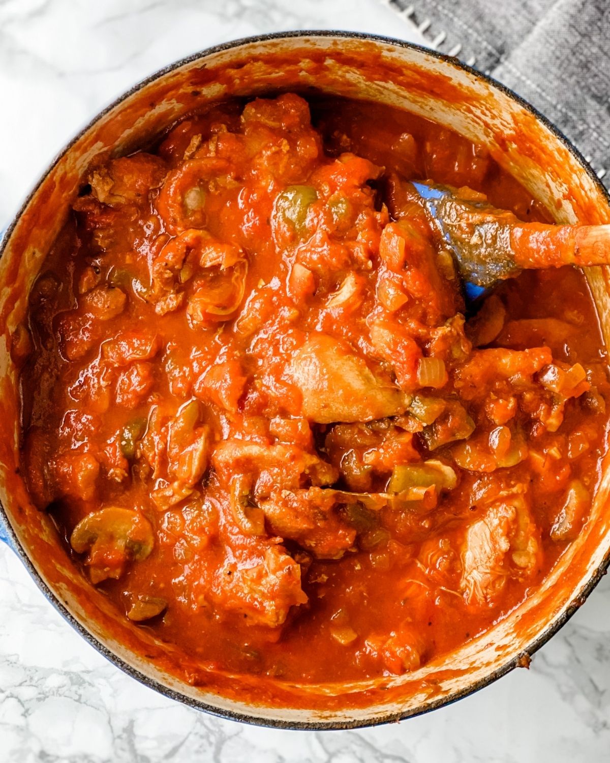 overhead picture of chicken cacciatore in a large pot.