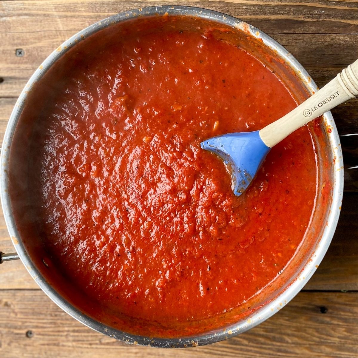 gluten-free marinara sauce in a sauce pan with a spoon.