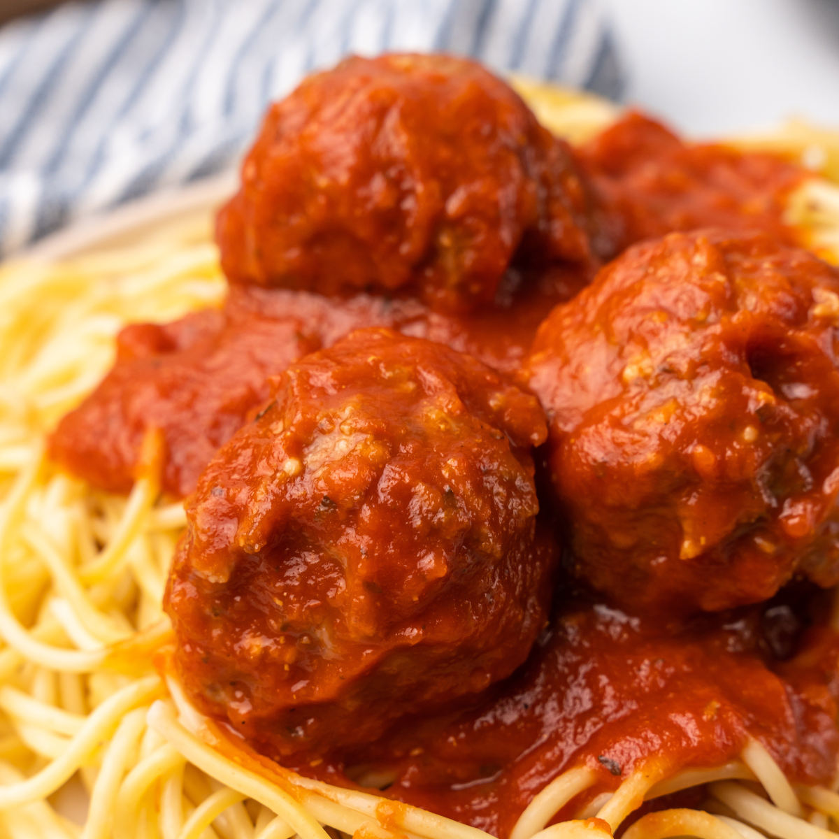 closeup picture of gluten free turkey meatballs on a plate of pasta.