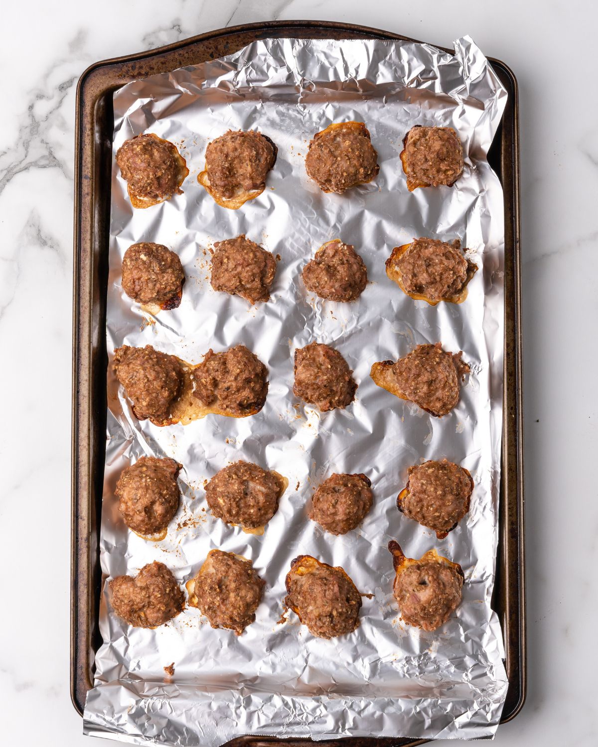 cooked turkey meatballs on a sheet pan with foil.