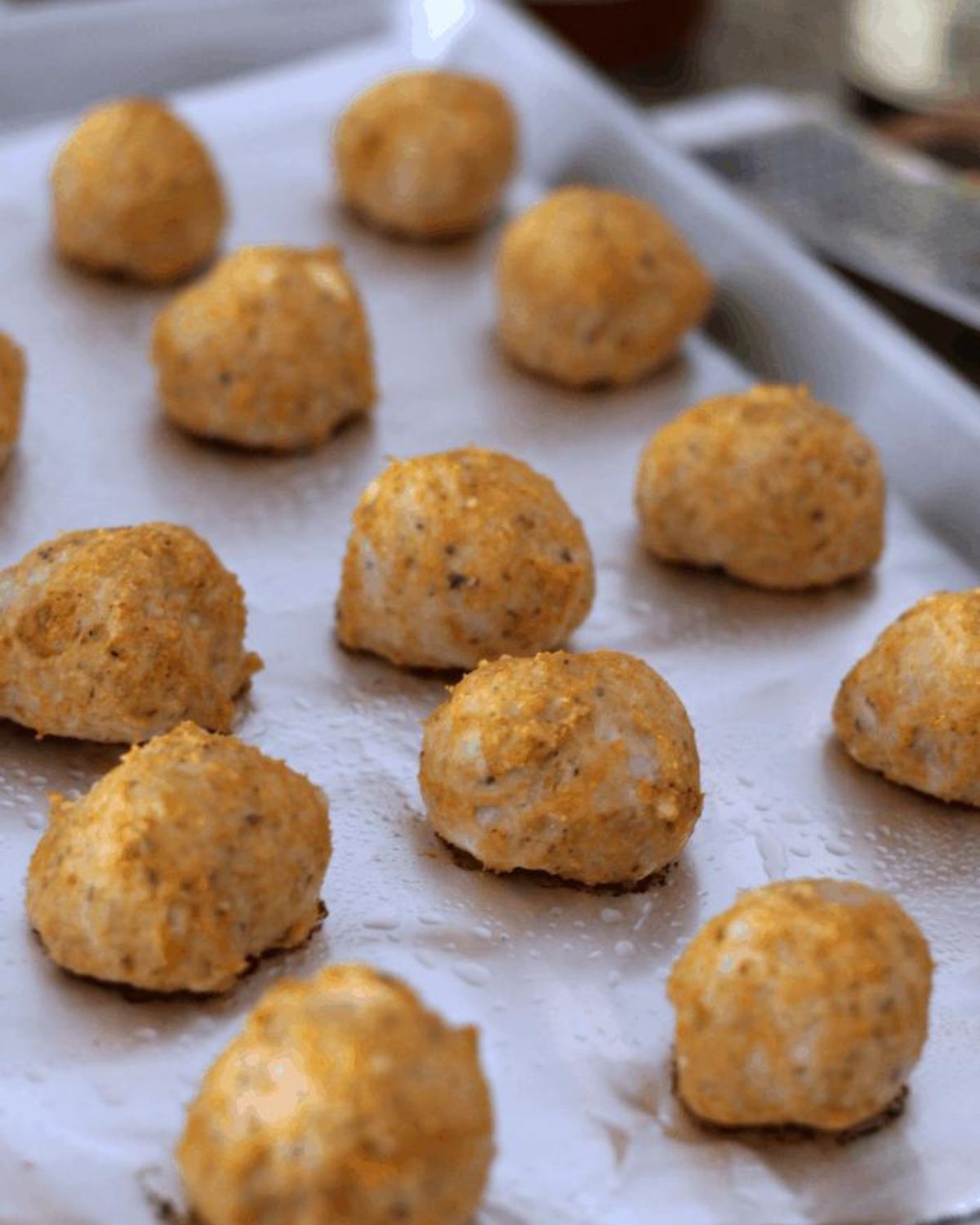 cooked chicken meatballs on a baking sheet.