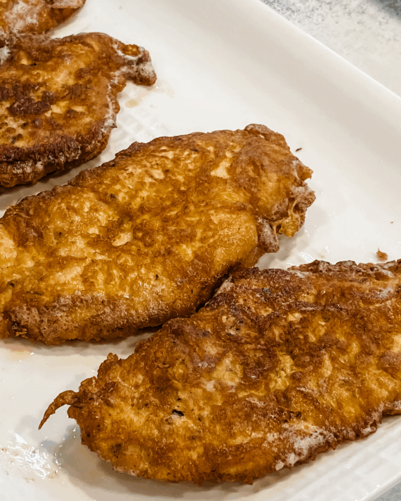 cooked chicken cutlets on a platter.