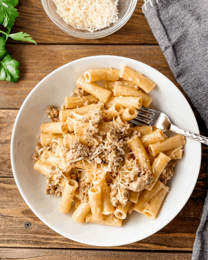 overhead of creamy pasta and sausage